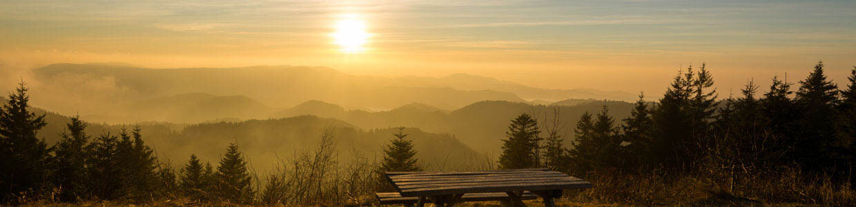 Ein Holztisch auf einer Anhöe mit Panoramablick bei Sonnenuntergang