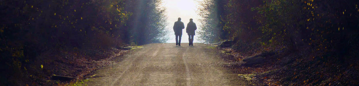 Zwei Menschen gehen einen Weg ins Licht entlang